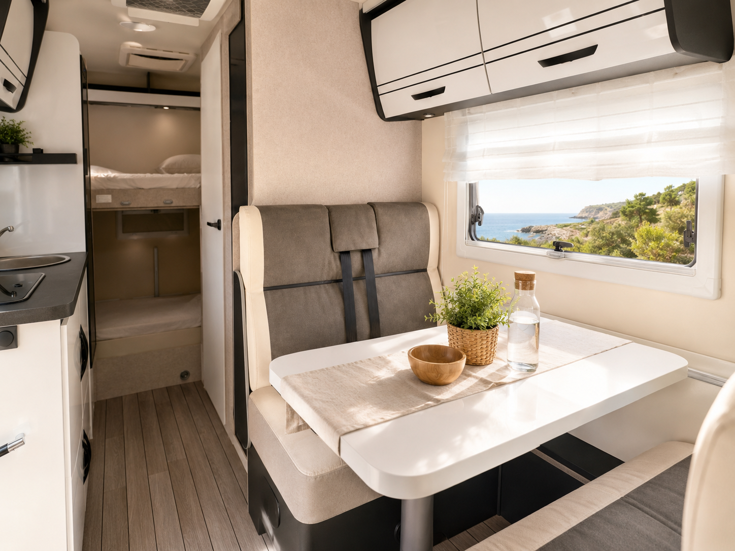 Salón luminoso de la autocaravana con mesa, asientos y vista al mar
